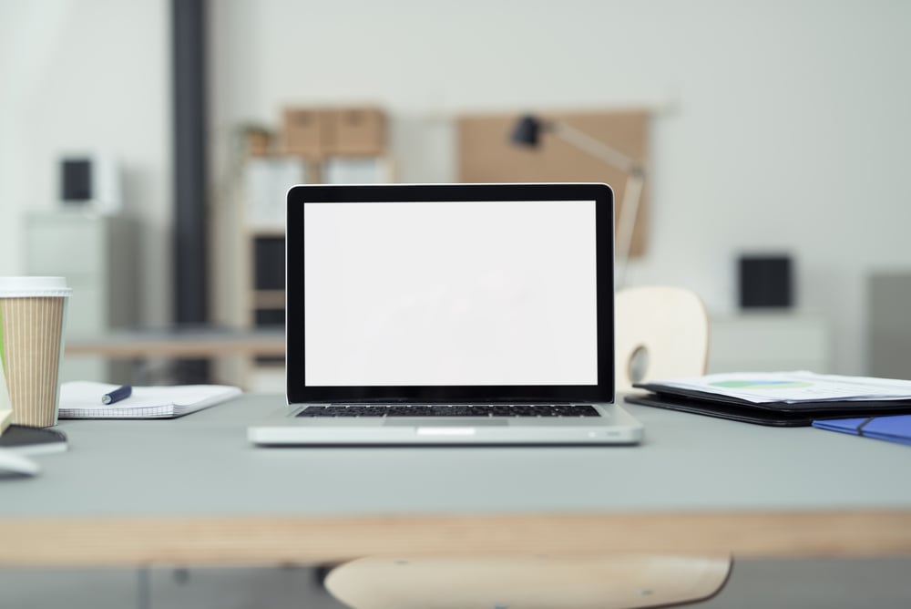 Close up Laptop Computer on Top of Office Table of a Businessman with Empty White Screen, Emphasizing Copy Space. Close up Laptop Computer on Top of Office Table of a Businessman with Empty White Screen, Emphasizing Copy Space.